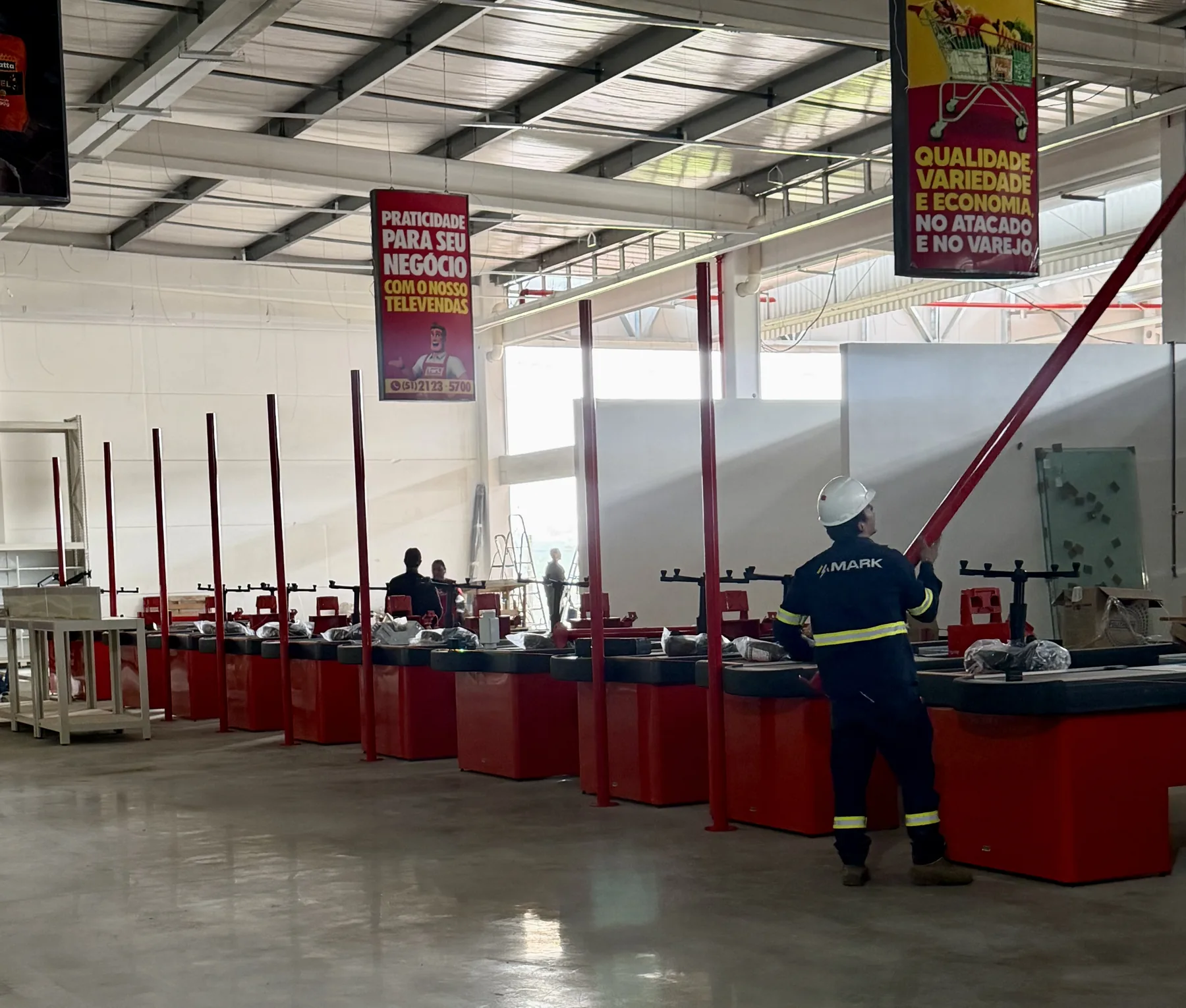 Profissional da MARK executando instalações na área de checkouts